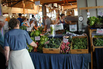 Shoppers at an indoor farmers' market stall